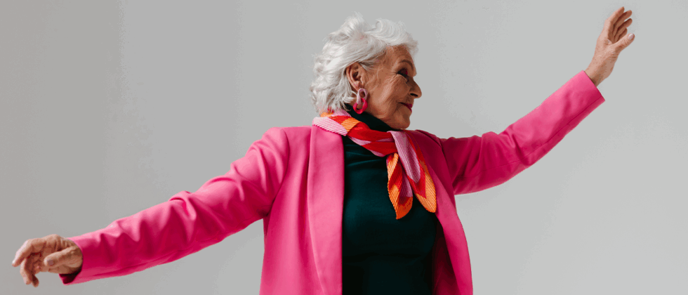 Person in pink jacket walking in the city, thoughtful moment.