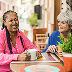 Smiling person holding a warm coffee mug at home.