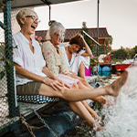 Feet splashing water at a lakeside, evoking joy and wellbeing.